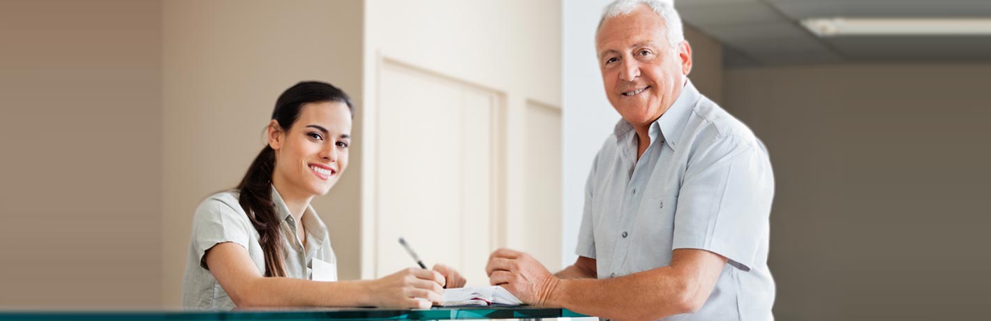 Image of patient and receptionist.