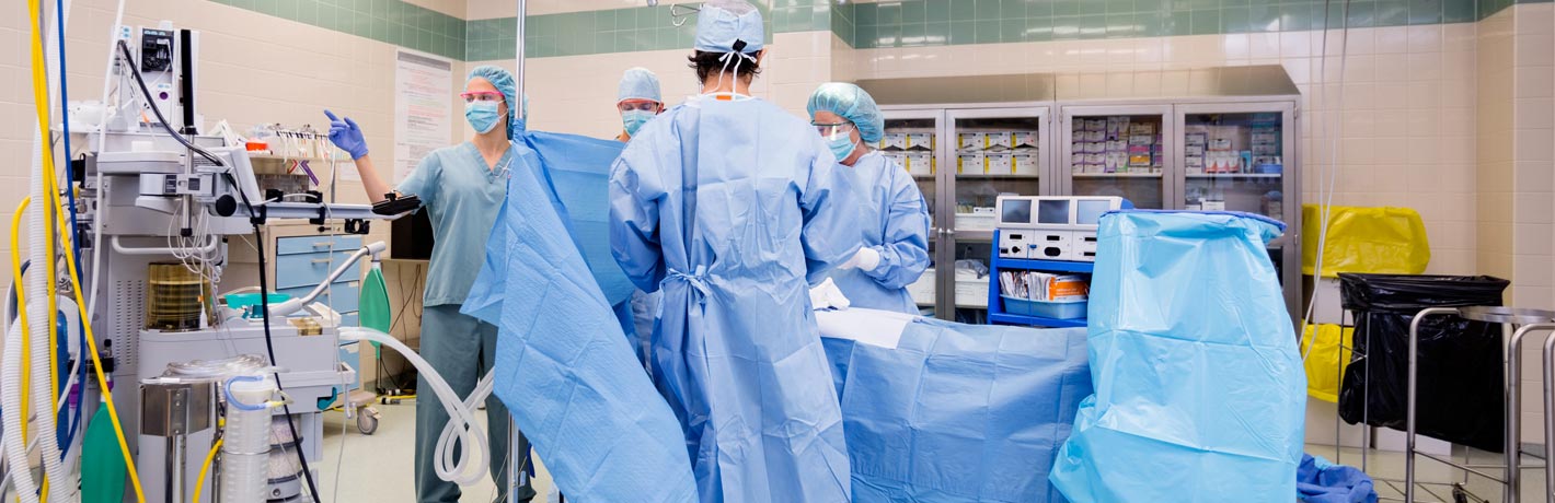 Image of doctors performing total hip replacement surgery in operating room.