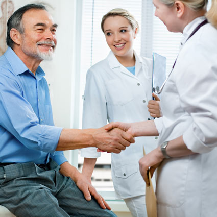 Image of two female nurses consulting a male patient.