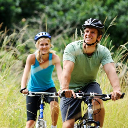 Young couple cycling after successful surgery.