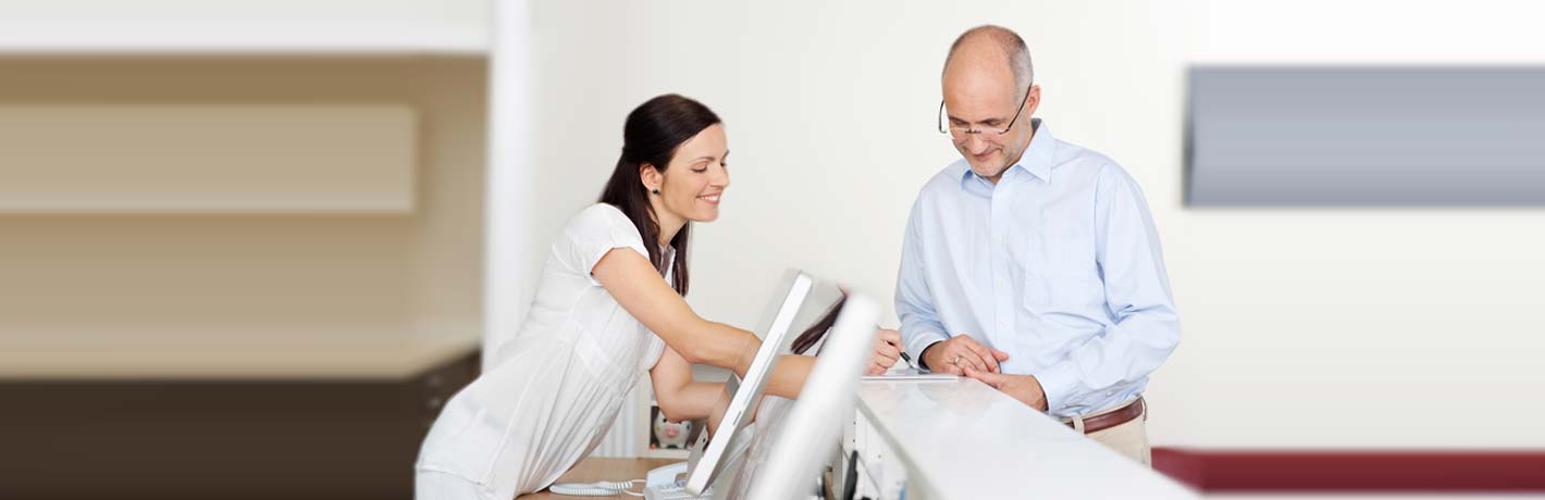 Image of receptionist assisting patient.