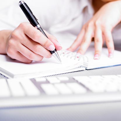 Image of woman copying surgery pre-op instructions into a notebook.